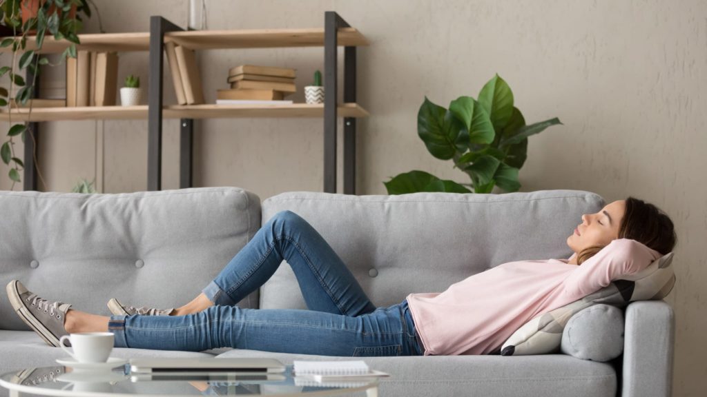 Woman relaxing at home breathing clean air