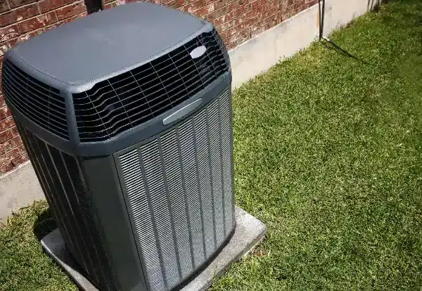 An air conditioning installation is shown in Beltsville, MD, with a central unit set on a concrete pad outside a brick building, surrounded by green grass.
