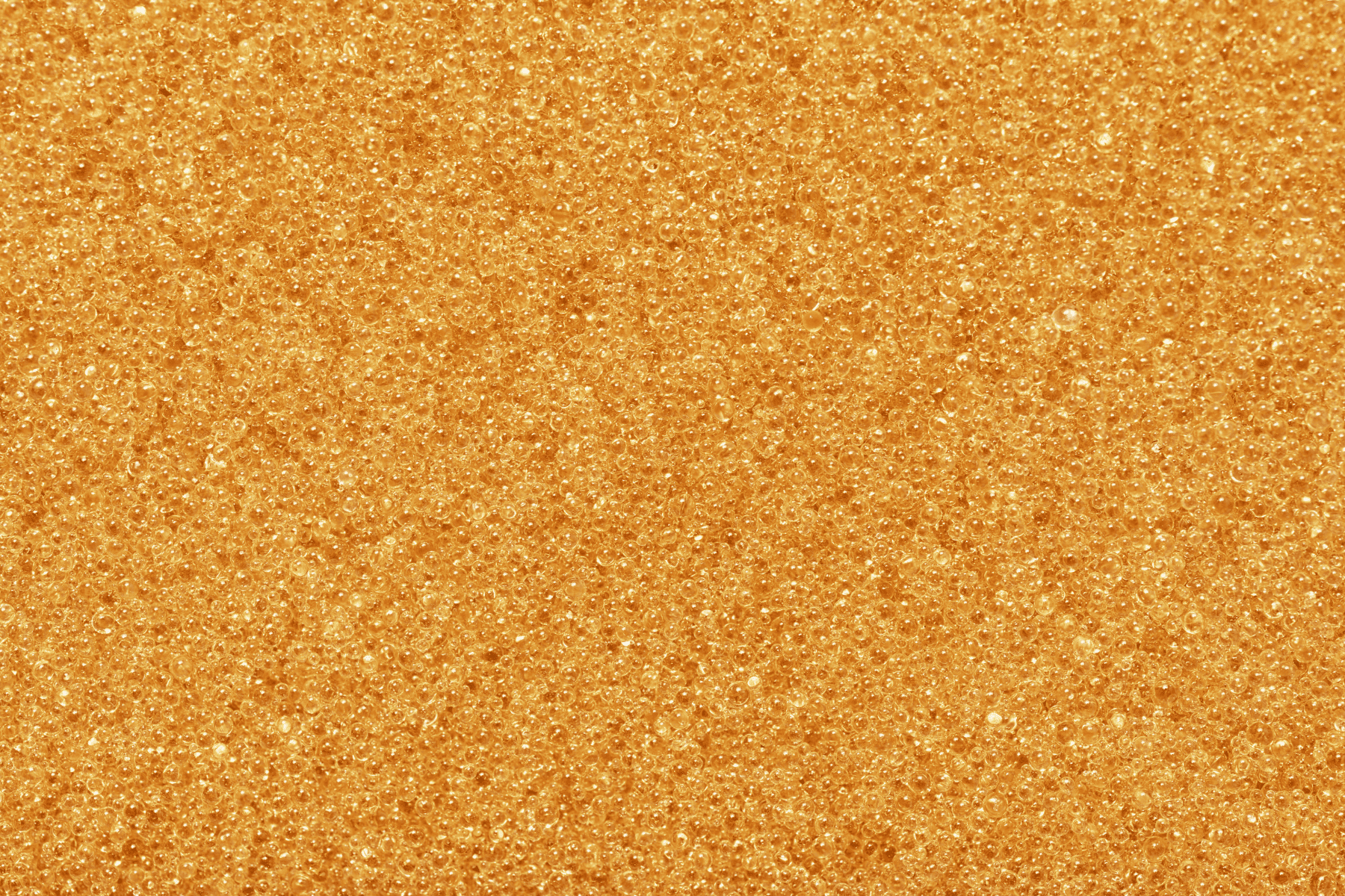Close-up of many small orange beads clustered together, creating a textured and uniform surface, reminiscent of water softener resin replacement media.
